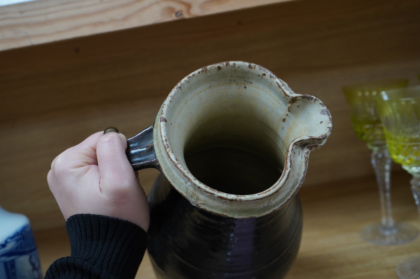 Richard Batterham (1936-2021), a tall stoneware black glazed jug, with a cream rim. 28cm high. Condition - good